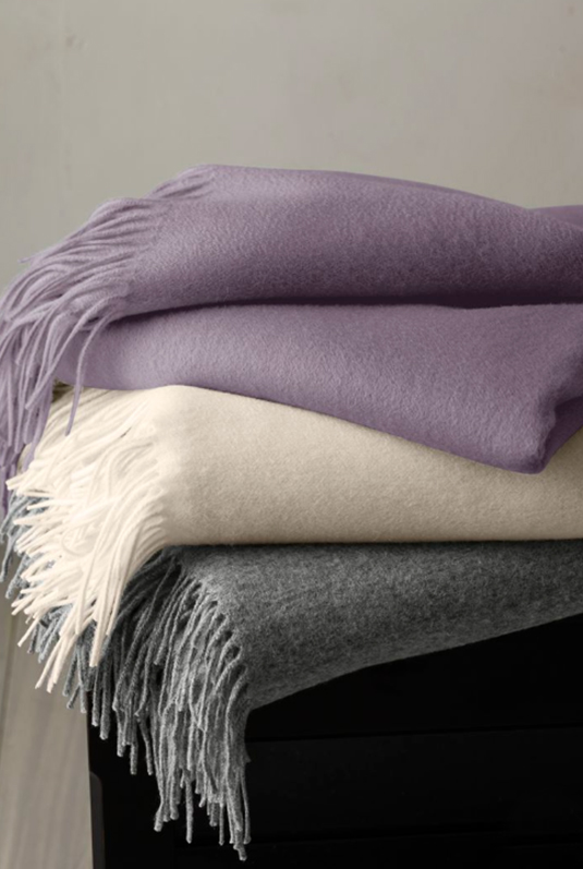 Durable wool upholstery fabric with detailed weave draped over furniture