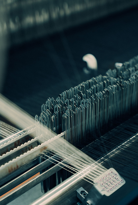 Technicians supervising modern automated looms during fabric weaving