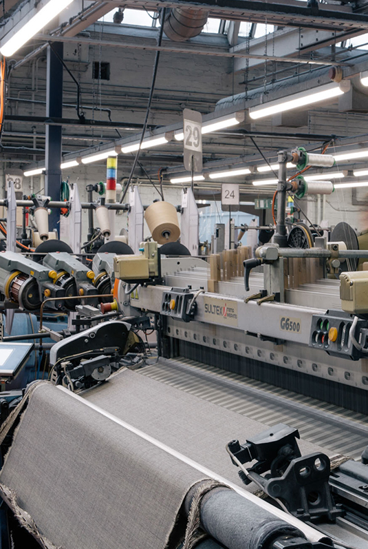 Close-up of fabric formation on a high-speed weaving loom