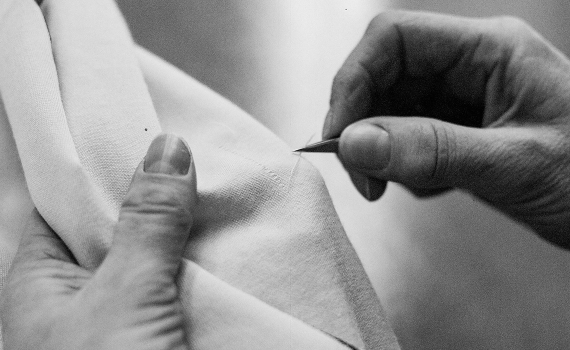 Worker conducting manual quality inspection of luxury woolen fabric